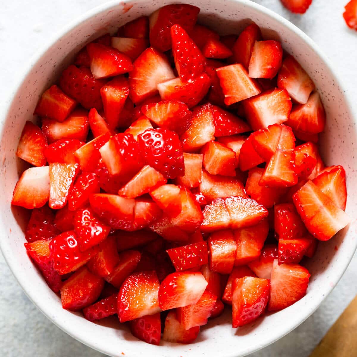 overhead shot of a bowl with chopped fresh strawberries