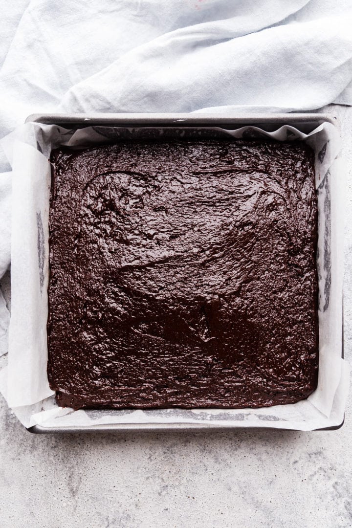top view of the baking tin filled with brownie batter layer