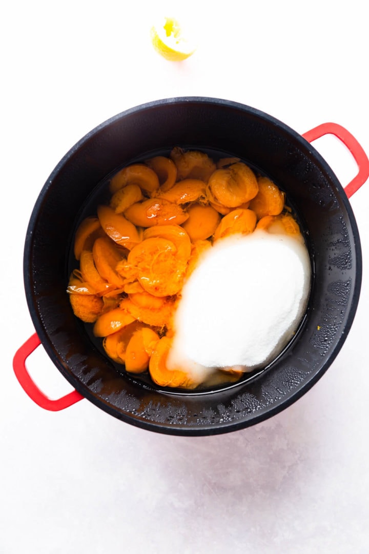 top view of a large pan filled with cooked apricots and sugar