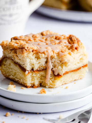 side super close up at a square slice of cake drizzled with cinnamon glaze
