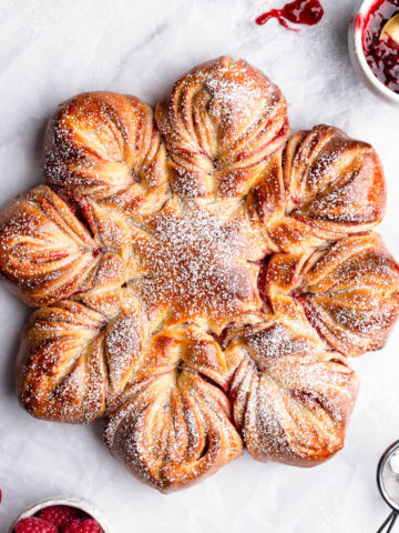 top view close up of a festive raspberry star bread dusted with icing sugar