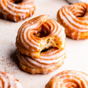 a side close up at a stack of two crullers with the top one missing a bite