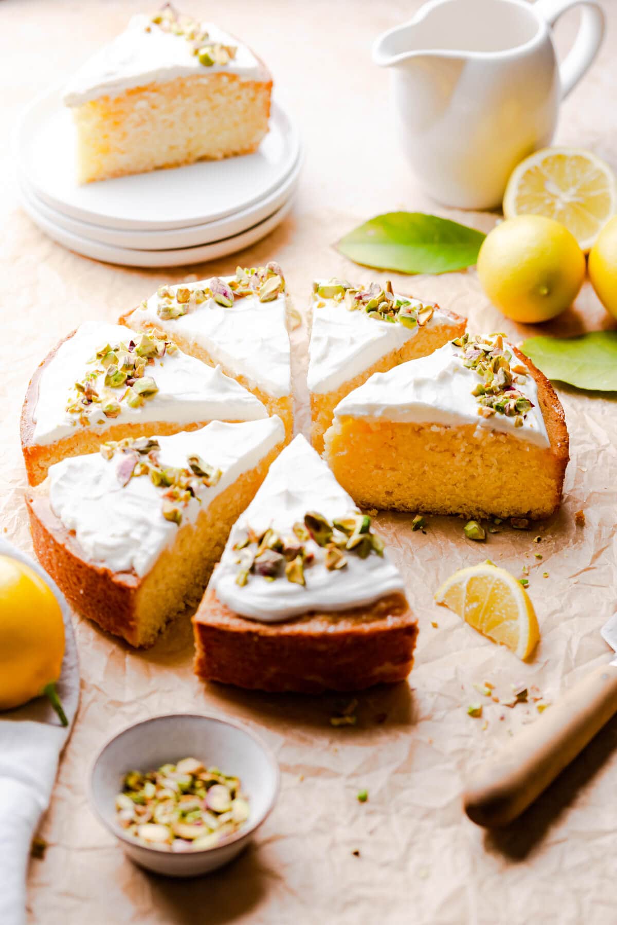 45 degree angle view of cake cut into slices and topped with yoghurt and pistachio nuts