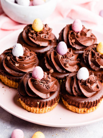 45 degree angle view at a plate filled with chocolate mini cheesecakes topped with mini eggs