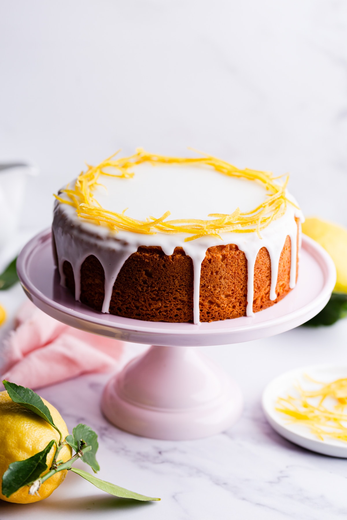 45 degree angle view of the zesty lemon cake on pink cake stand