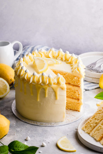 lemon and elderflower cake on a cake board with slice cut out