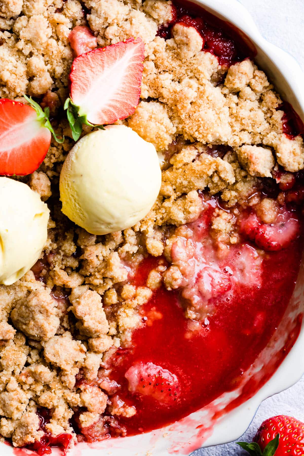 top down close up of a crumble dessert with strawberry sauce underneath