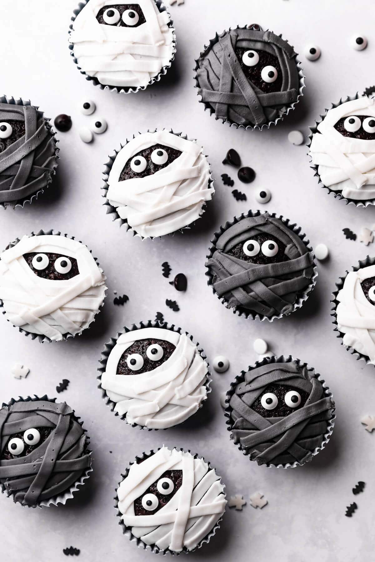 chocolate cupcakes decorated with white and black icing and sugar eyes.