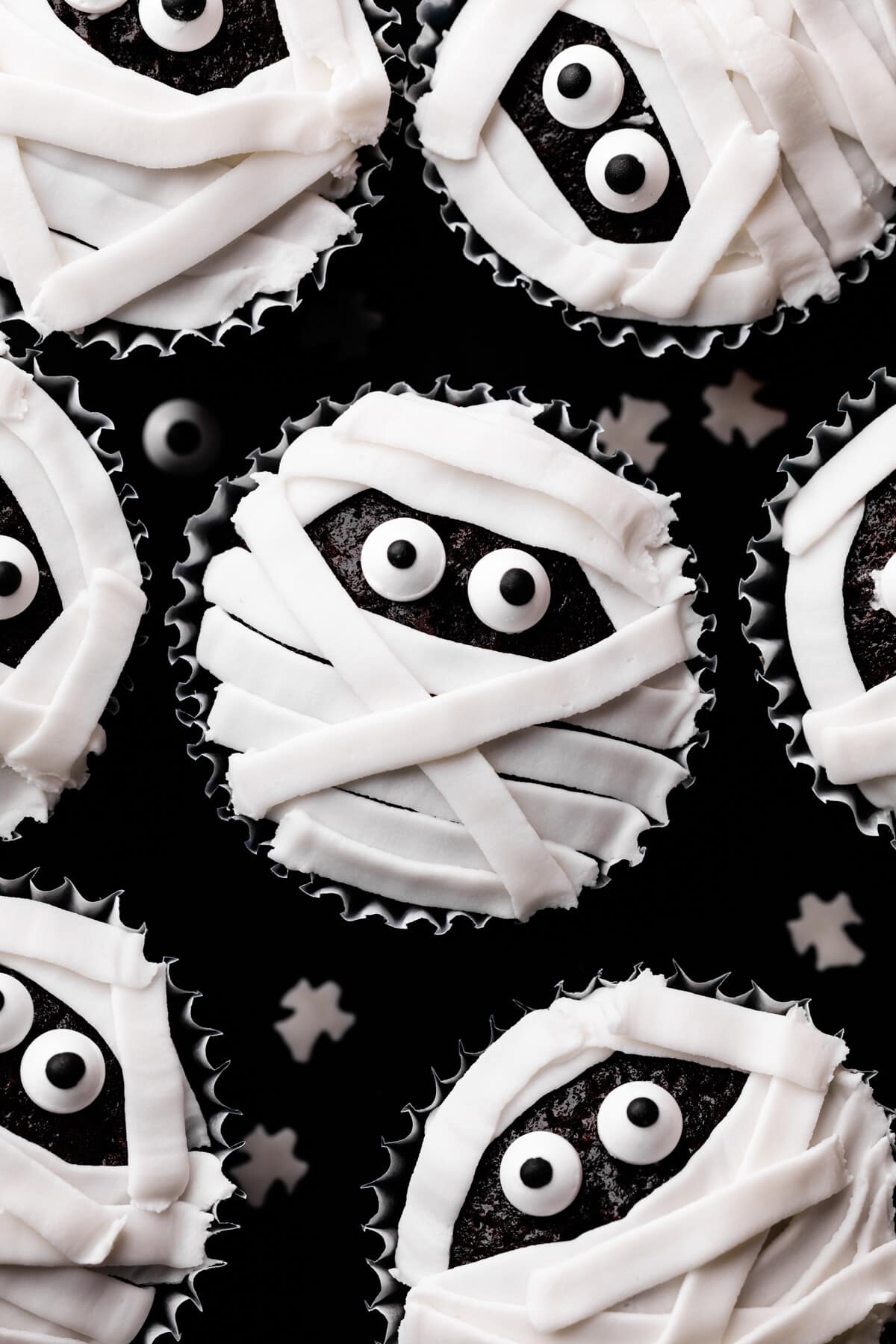 chocolate cupcake with white icing and candy eyes decoration.