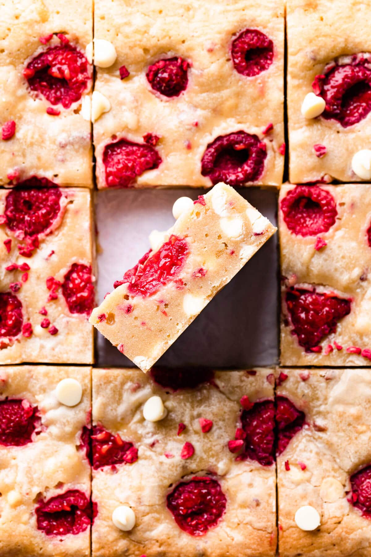 square slices of raspberry blondies studded with fresh raspberries.