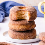 three air fryer doughnuts with sugar coating on top of each other.