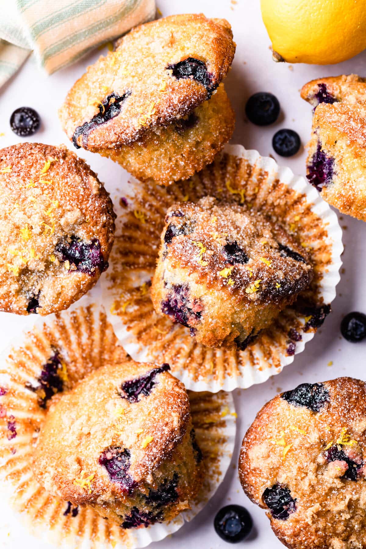 blueberry and lemon muffins dusted with icing sugar on a bright background.