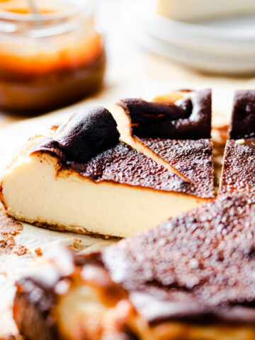 burnt basque cheesecake with some individual slices sliced out of it.