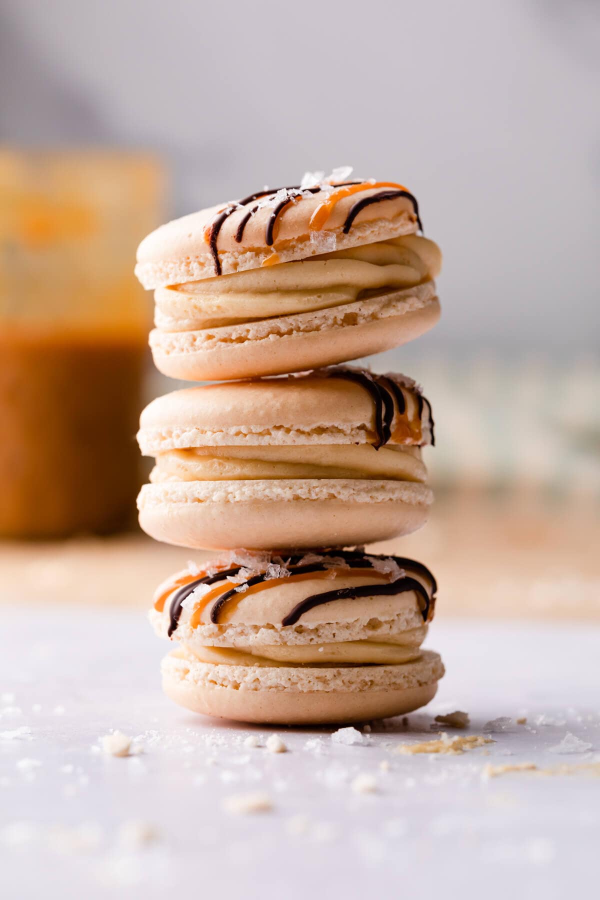 three salted caramel macarons stacked on top of each other.