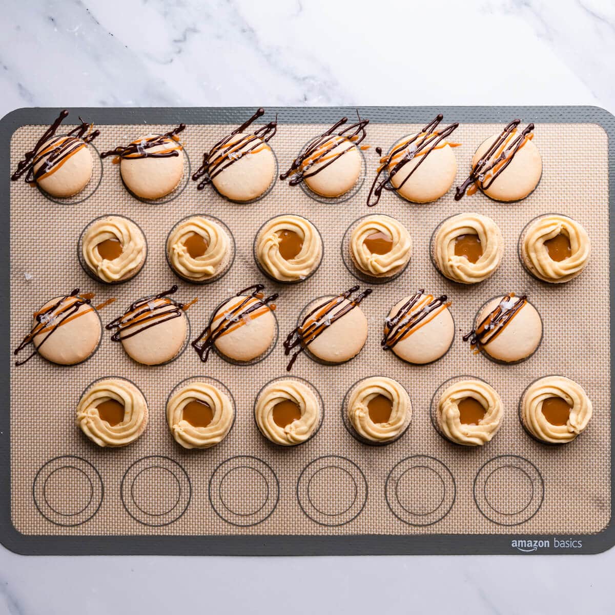 salted caramel macarons shells with chocolate and caramel drizzle and buttercream filling.