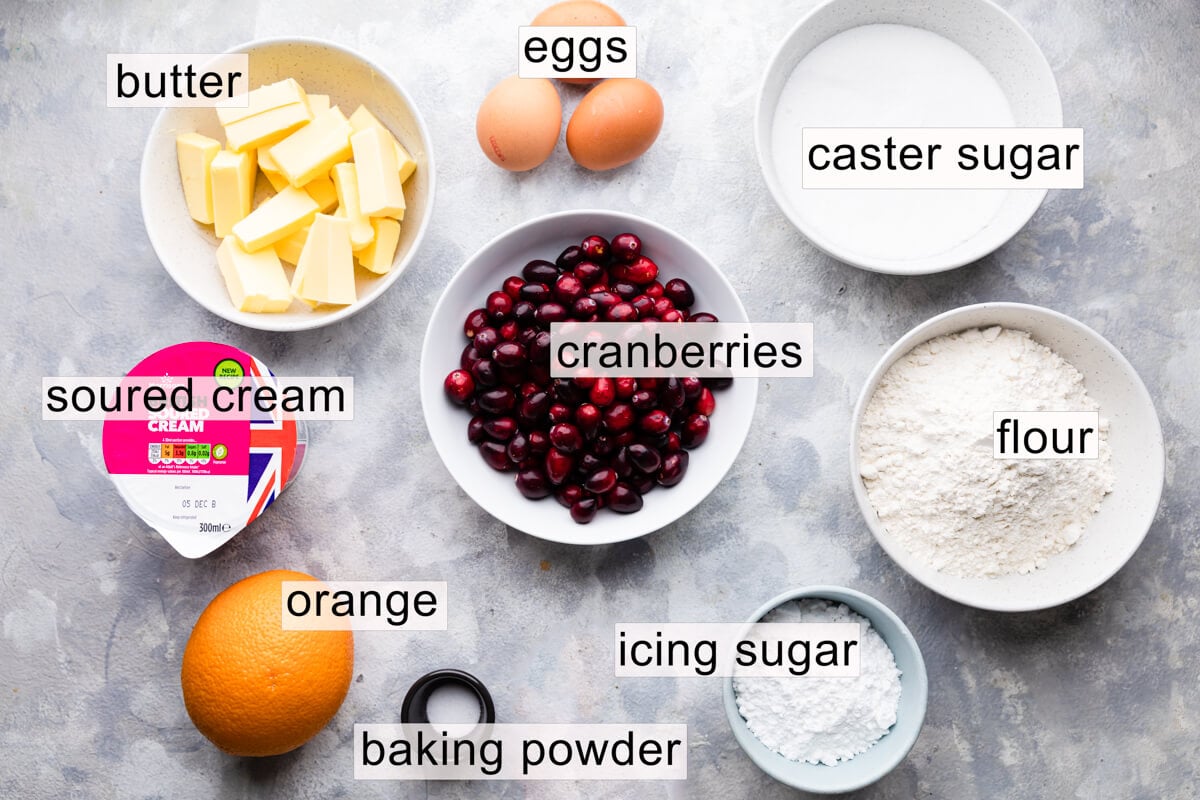 ingredients to make orange cranberry loaf cake with text labels