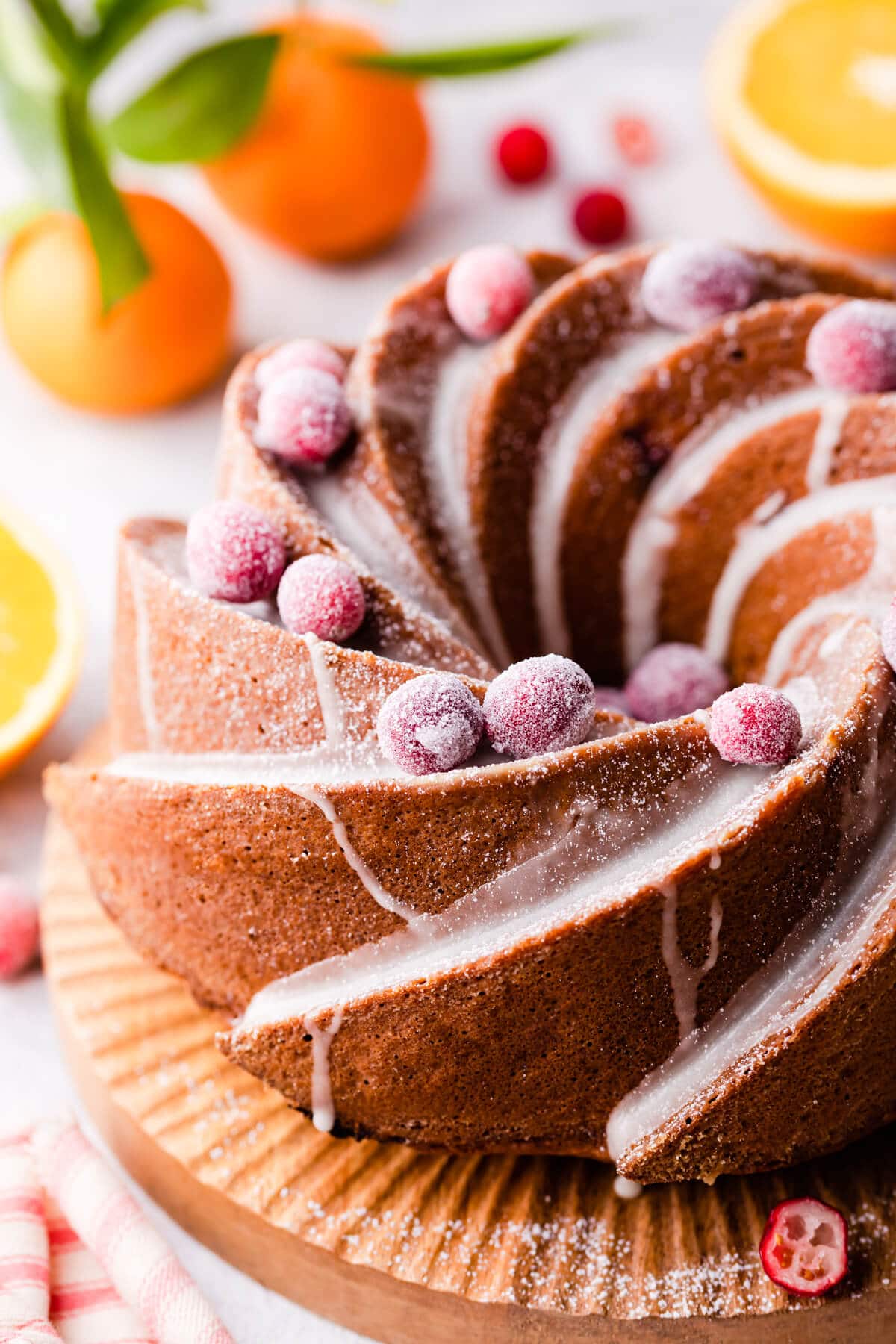 orange cranberry bundt cake topped with glaze and sugared cranberries.