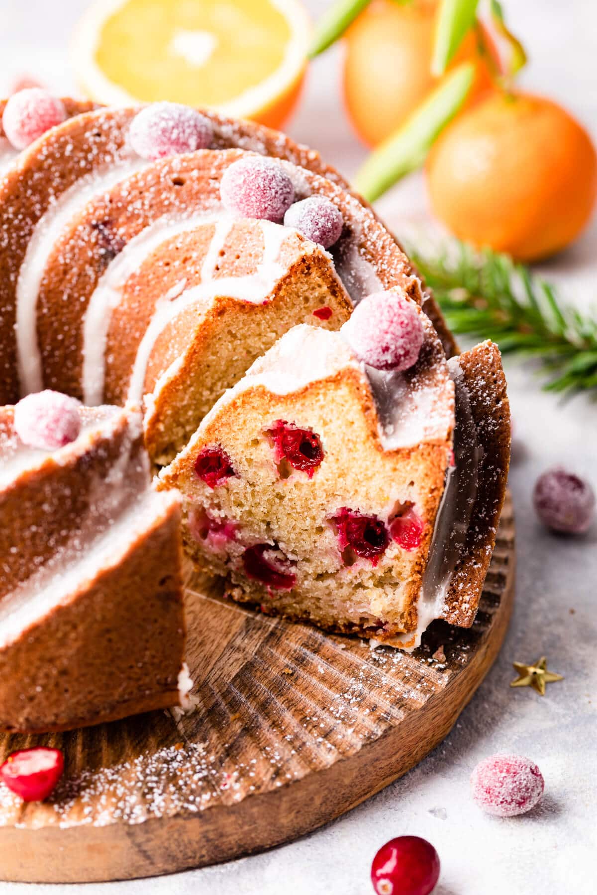 orange cranberry bundt cake with slice cut out of it.
