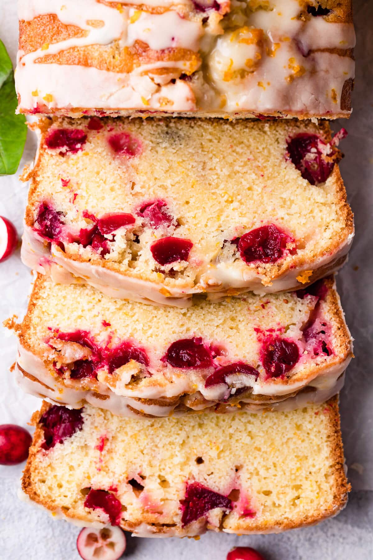 three slices of the orange cranberry loaf with citrus glaze.