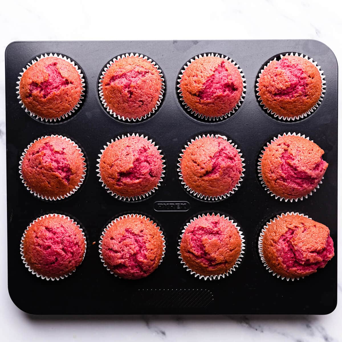 baked raspberry cupcakes inside of the baking tin.