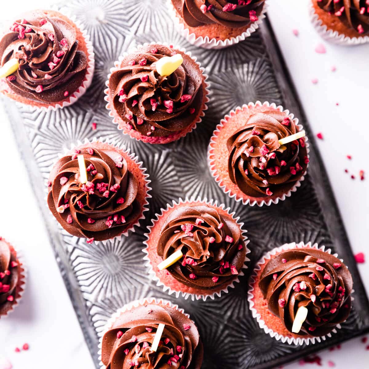 raspberry cupcakes topped with swirls of chocolate buttercream.