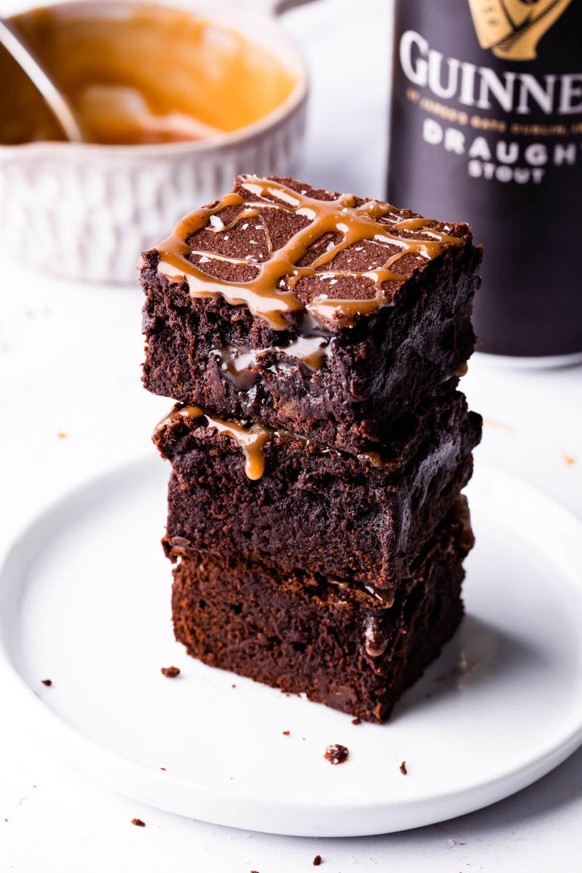 stack of Guinness brownies on a white dessert plate with can of Guinness behind it.