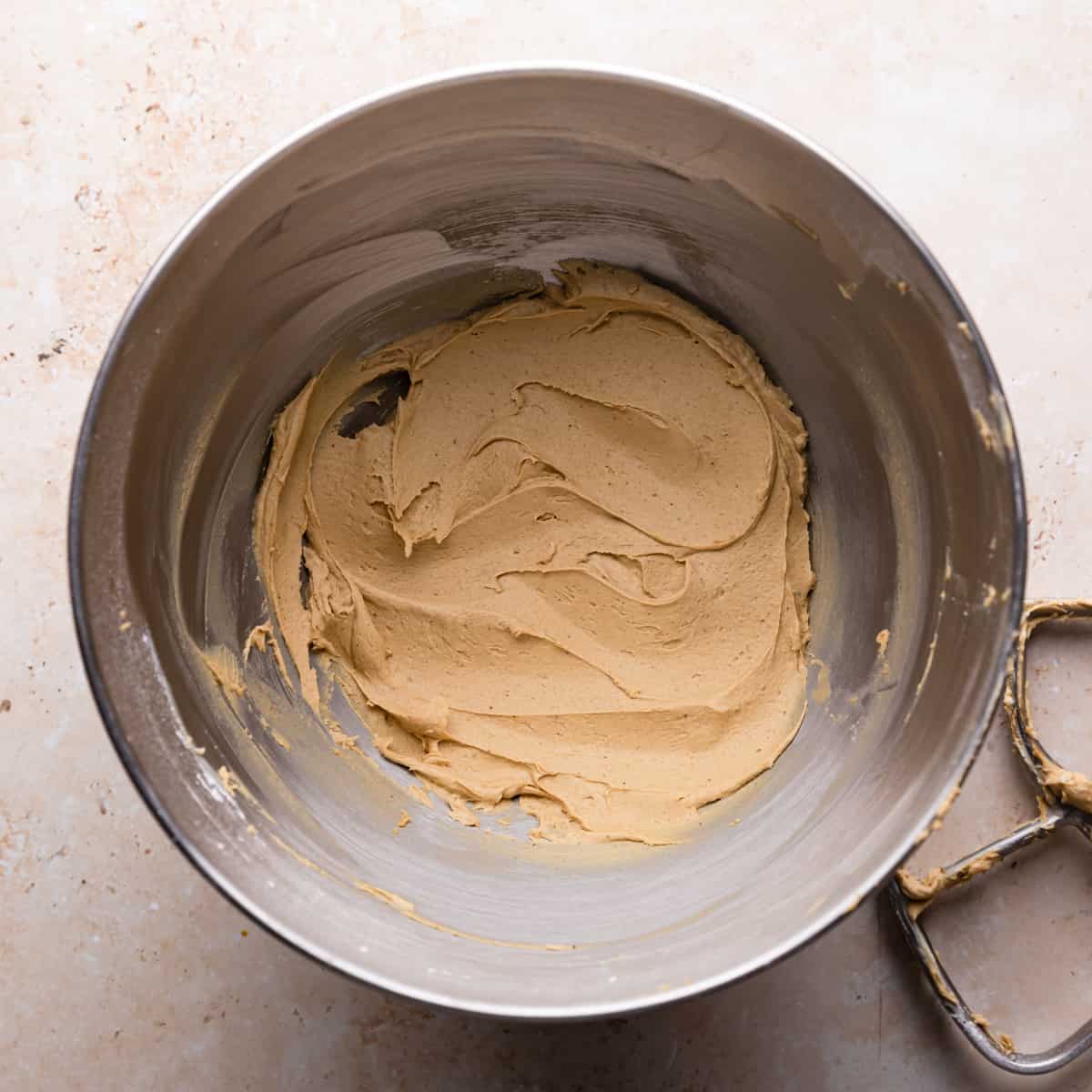metal mixing bowl with gingerbread buttercream.
