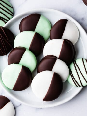 green and white peppermint creams dipped in chocolate on a small white plate