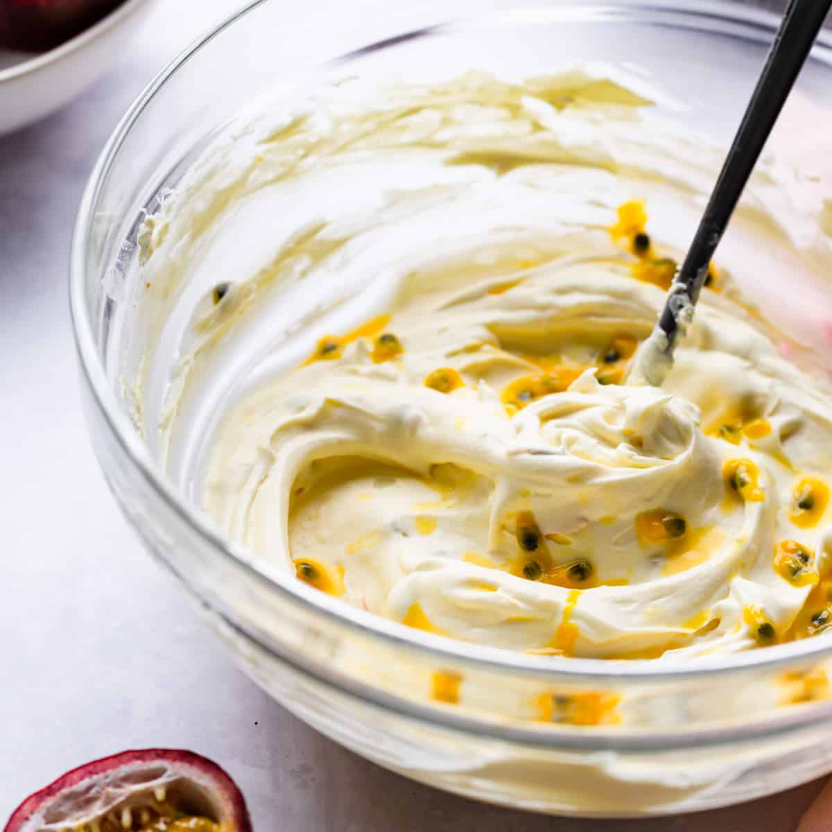 bowl with whipped mascarpone cheese and passion fruit seeds.